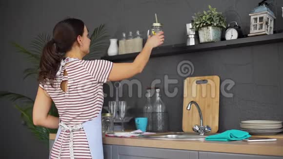 家庭主妇把干净的杯子放在架子上视频的预览图