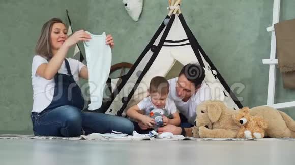 母亲在丈夫和儿子身边叠衣服视频的预览图