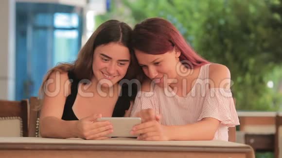 两个年轻女孩在智能手机上看电影视频的预览图