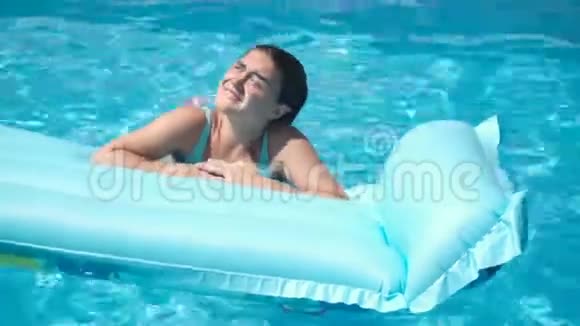 躺在游泳池床垫上的年轻女孩视频的预览图
