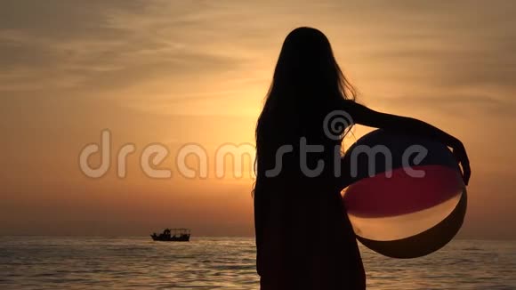 海滩上的孩子日落时在海滨玩耍的孩子海岸边看海浪的小女孩视频的预览图