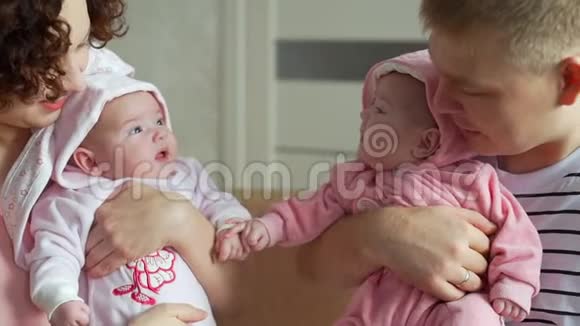 家中父母手上可爱的双胞胎宝宝视频的预览图