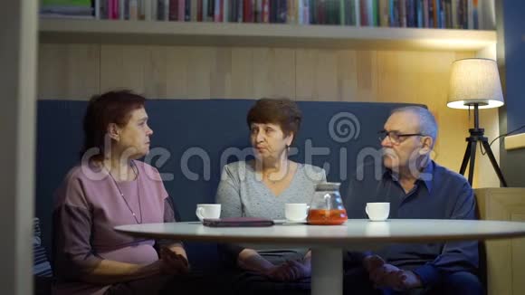 三位高级朋友谈论咖啡馆的生活视频的预览图