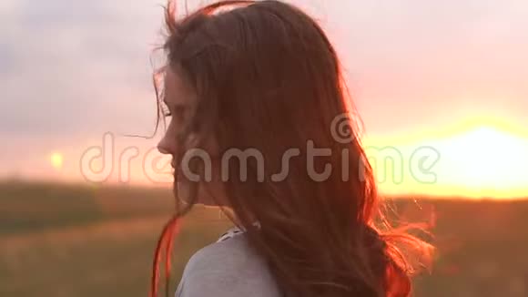 日落时留着长发的女孩的剪影特写视频的预览图