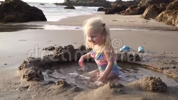 金发女孩在海边的沙滩上玩耍视频的预览图