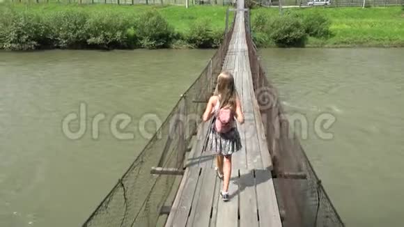 儿童在山桥上儿童在大自然中远足女孩在河流中寻找视频的预览图