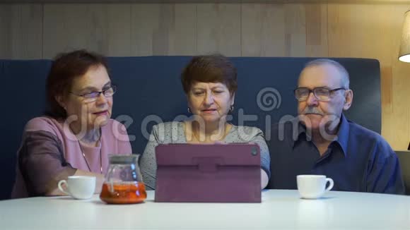 老年人在平板电脑上观看相册视频的预览图
