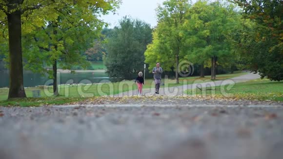 母亲和女儿在城市公园跑步视频的预览图