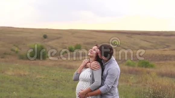 丈夫在田里拥抱他心爱的怀孕妻子他们笑了视频的预览图