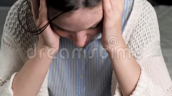 头痛心烦意乱的女人双手抱着头低头看着偏头痛血压压力颅内视频的预览图