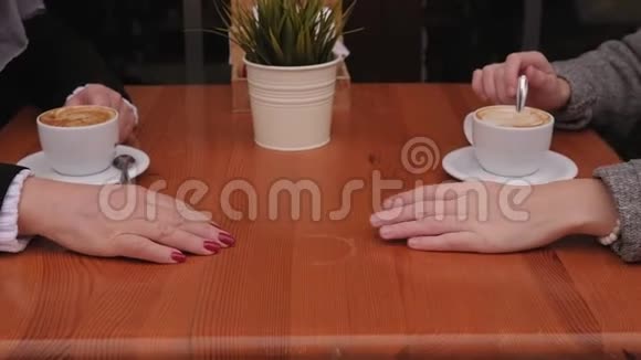一位年轻女子和一位年迈的母亲在咖啡馆的一张桌子上的手视频的预览图