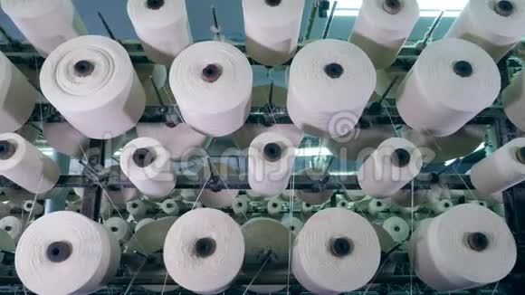 在纺织厂里带螺纹的球茎在机架上旋转工业面料生产线视频的预览图