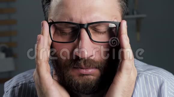 头痛男人用双手闭上眼睛触摸他的头偏头痛血压压力眼睛疲劳的概念前线视频的预览图