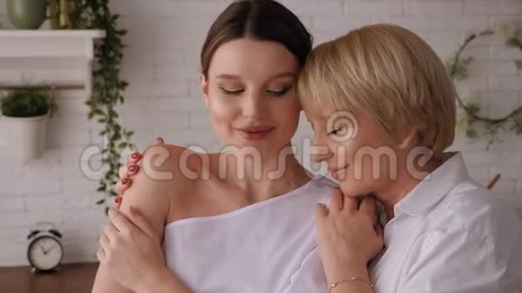 一个成年女儿在家中厨房里拥抱她年迈的母亲视频的预览图
