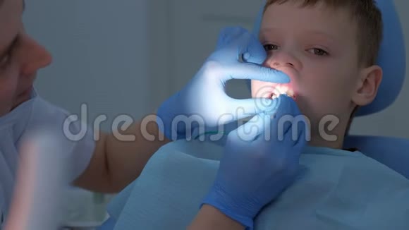 牙科医生卫生员用刷子把氟涂在青少年牙齿上视频的预览图