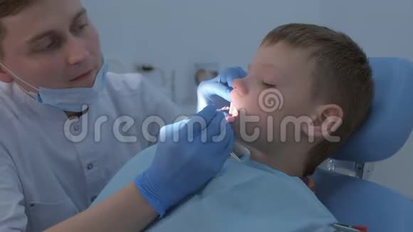 牙科医生为保护男孩清洁后的牙齿做了氟化处理视频的预览图