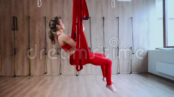 健身女孩在健身课上练习瑜伽体式和吊床的侧面视图视频的预览图