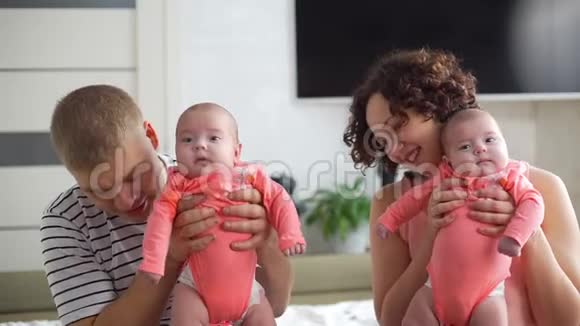 家中抱双胞胎婴儿的年轻父母视频的预览图