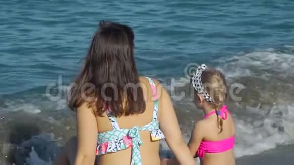 小女孩和妈妈一起享受温暖的海水视频的预览图