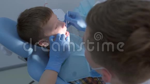 牙科医生为保护儿童清洁后的牙齿做了氟化处理视频的预览图