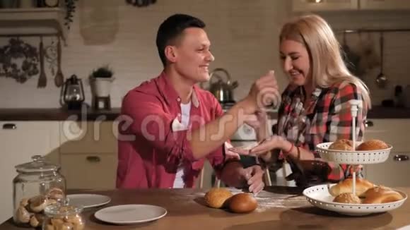 有魅力的一对夫妇在厨房做饭用面粉玩视频的预览图