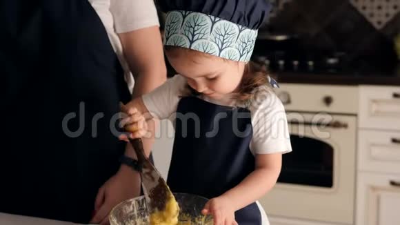小可爱的女孩一边吃面团一边在家里厨房做饼干视频的预览图