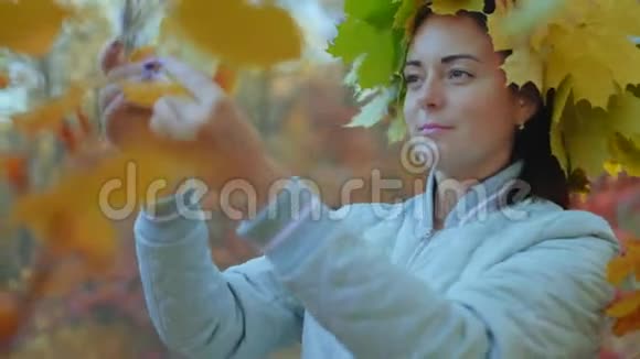 从黄秋叶树上撕下来的美丽女子视频的预览图