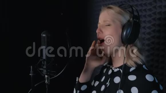 女歌手在录音室的麦克风录音歌曲中有感情地演唱视频的预览图