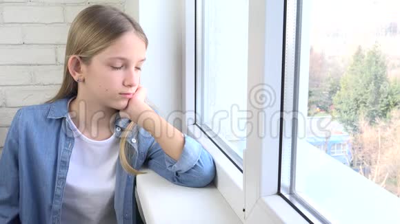 伤心的孩子望着窗外无聊体贴的少年女孩忧郁的孩子脸视频的预览图
