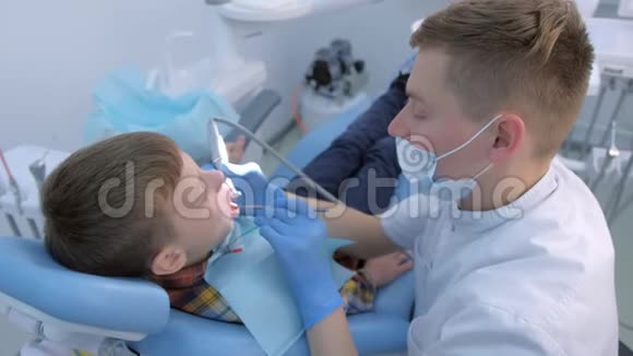 牙医卫生员在牙科为少年儿童做口腔卫生清洁视频的预览图