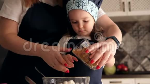 小女孩帮妈妈准备面团她把葡萄干倒成面团视频的预览图
