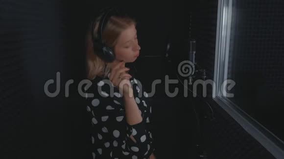 女歌手关掉耳机结束麦克风录音歌曲的演唱视频的预览图