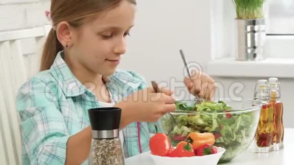孩子吃绿色沙拉孩子在厨房孩子做饭女孩吃新鲜蔬菜烹饪健康的食品视频的预览图
