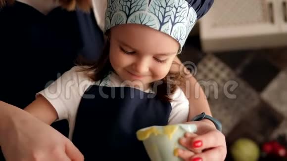 小可爱专注的女孩把面团放在烤盘里妈妈帮她视频的预览图