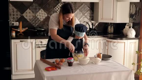 一对母女在厨房里一起准备面团的特写镜头视频的预览图