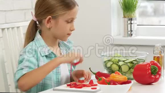 孩子在厨房准备绿色沙拉孩子切蔬菜女孩健康食品视频的预览图