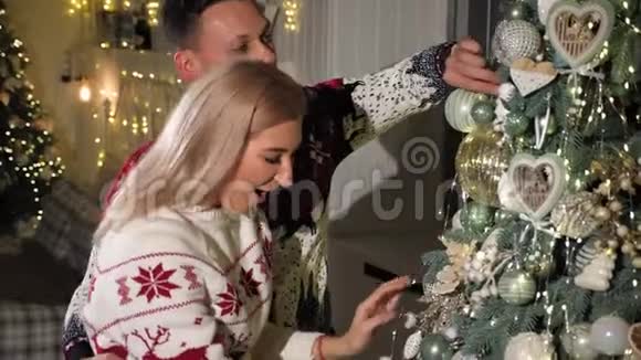 新婚夫妇在家装饰圣诞树的特写镜头视频的预览图