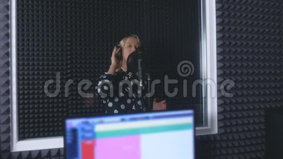 女歌手在麦克风唱歌在录音室录制歌曲视频的预览图