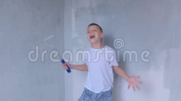 儿童少年玩跳和与油漆滚筒为绘画墙壁视频的预览图