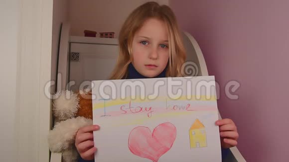 可爱悲伤的小白种人女孩手里拿着海报我呆在家里视频的预览图