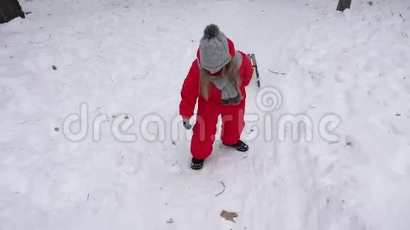 孩子们在雪地里滑孩子们在冬天玩耍小女孩在公园里滑视频的预览图