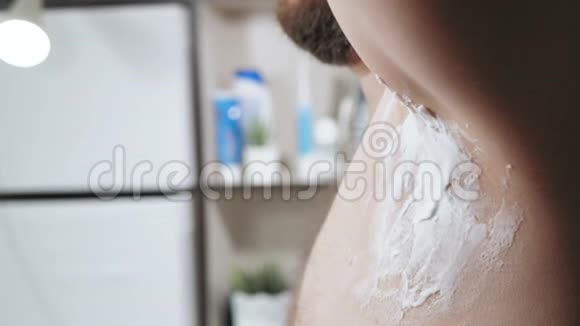 男人剃他的腋窝浴室里白种人留胡子的人用一次性刀片剃掉他的左腋窝视频的预览图