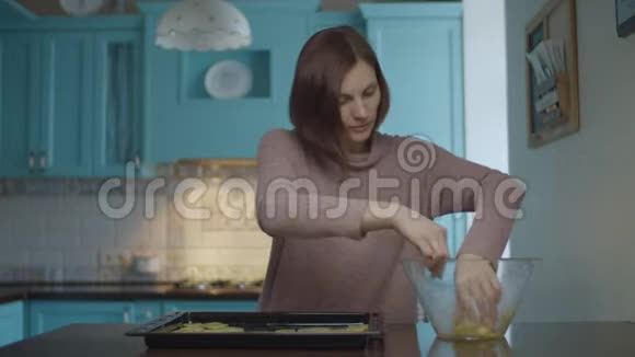 年轻女子在家里煮薯片的时候把土豆片放在滴水锅上女人拿着平底锅出去视频的预览图