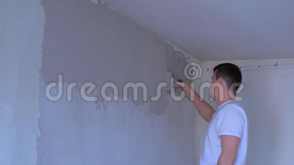 抹灰工人用腻子粉刷墙面用抹子对齐墙面视频的预览图