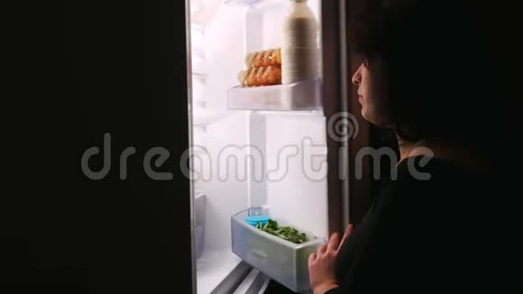 女孩晚上打开冰箱门拿出蛋糕视频的预览图