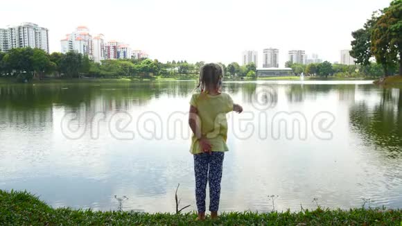 一个女孩正在池塘里寻找鱼视频的预览图