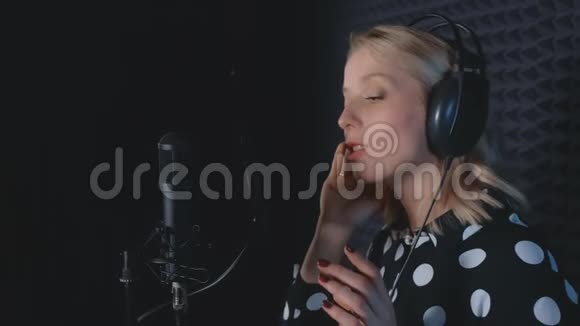 女歌手在录音室的麦克风录音歌曲中有感情地演唱视频的预览图