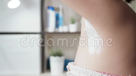 女人剃掉腋窝浴室里迷人的年轻女孩的侧视用一次性轻轻剃掉她的左腋窝视频的预览图