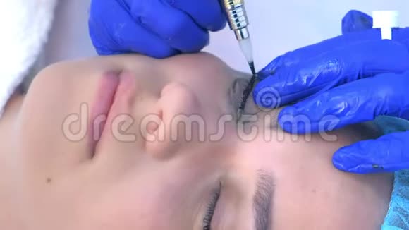 美容师给女性做永久性眼线化妆侧视视频的预览图