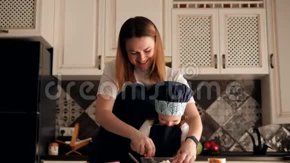 笑着妈妈和一个小可爱的女儿一起在厨房准备甜点视频的预览图